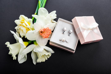 Set of pearl jewellery in gift box with flowers. Silver earrings and ring with pearls as a present for Mother's day.