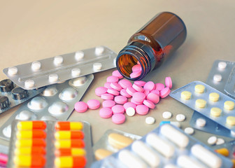 Composition of medicine bottle and pills on gray background. 