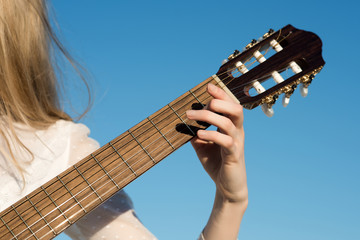 Hand play on string instrument. Guitar with fingers strumming strings. Classic guitar neck...
