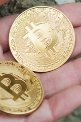  female hand holds the two coins.  Vertical view.