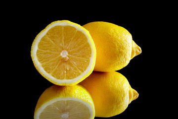 Lemons on a black reflective background