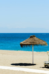 Beautiful sandy beach with palm tree umbrellas and blue sea