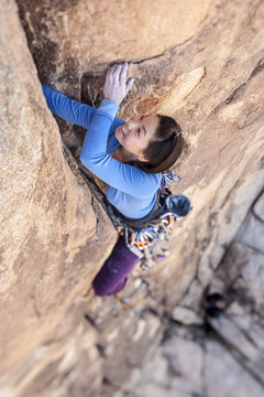 Rock climber clinging to a cliff.