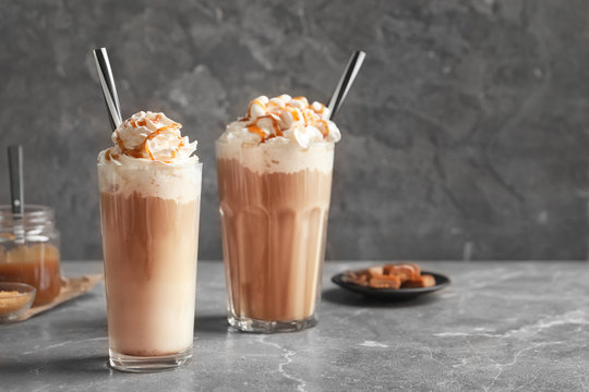 Glasses with delicious caramel frappe on table
