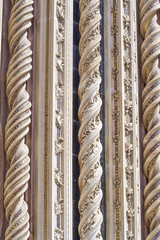 Detail of the facade of the cathedral of Orvieto, Italy. Spiral marble columns decorated with mosaics