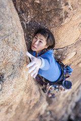Rock climber clinging to a cliff.