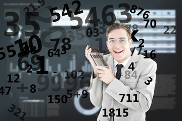Geeky smiling businessman holding calculator against business interface with graphs and data
