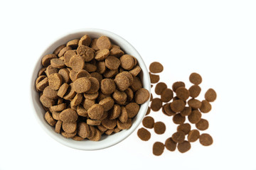 Dogs or cats dry food in a white bowl isolated on white background, top view
