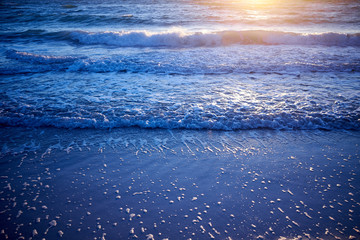 Golden glow of sunset over gently lapping waves