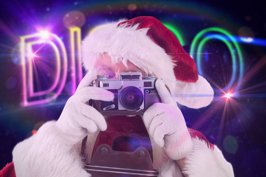 Santa is taking a picture against digitally generated colourful disco text