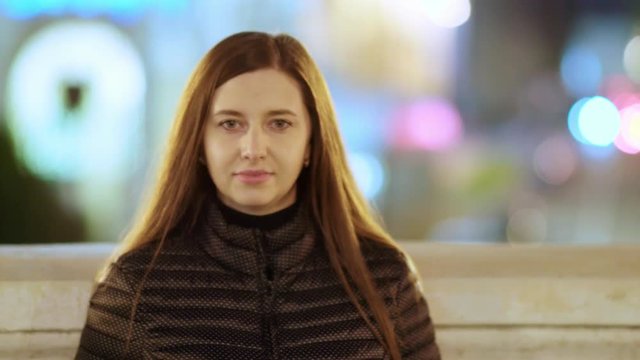 Portrait of a young woman in a big city at night.