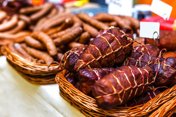 Smoked meat and sausages in wicker baskets sold on the market