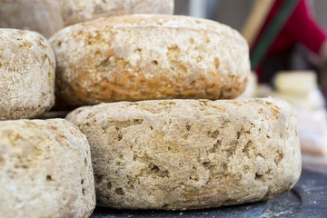 rustic french cheese wheels stacked on the marketplace