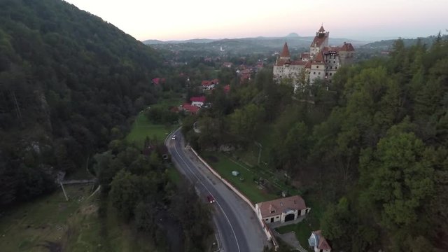 Aerial of Bran Castle on a hill near a village