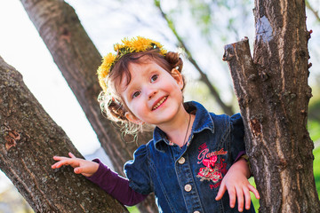 child is smiling on tree. girl climbed tree.