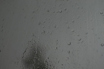 rain drops on glass on a dark background