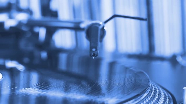 DJ headshell on spinning turntable. Blue Tone