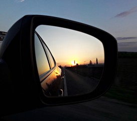 Rear view mirror reflecting sunset 