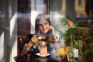 girl drinks coffee and watches video on mobile phone