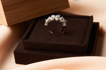 Fototapeta na wymiar Wedding diamond ring with gift box, close-up. Luxury female jewellery, selective focus