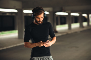 Young man resting and listen to music after jogging