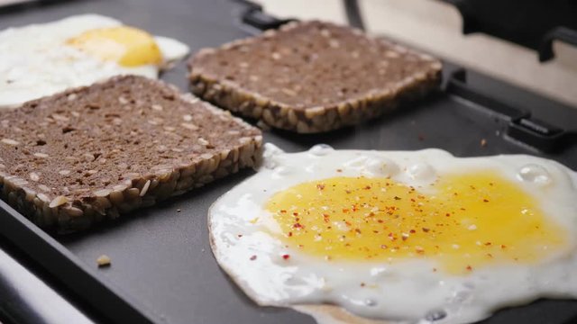 Cooking fried eggs and toasts
