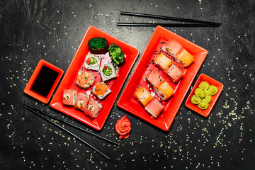 Set of sushi, Japanese knife, chopsticks and on dark stone table. Top view with copy space. Wasabi, soy sauce. Sushi on a table.