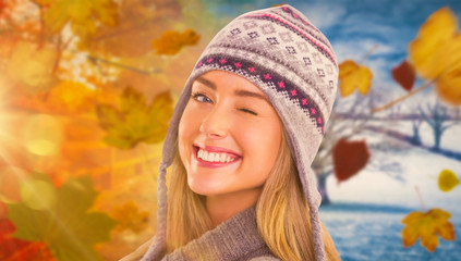 Happy blonde in winter clothes posing against autumn turning to winter