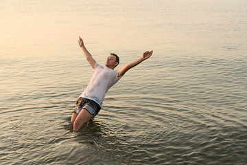 Young man falling in the water with his back