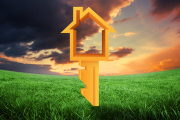 House key against green field under orange sky
