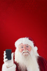 Santa Claus shows a smartphone against red background