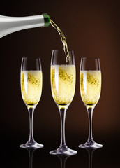 Champagne pouring against dark brown background