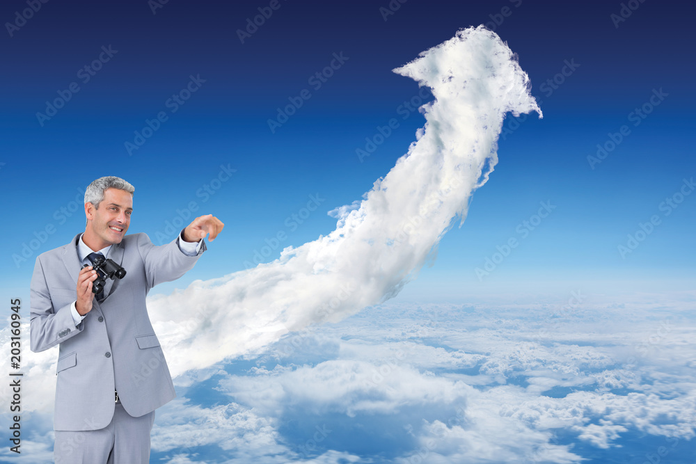 Wall mural Businessman holding binoculars and pointing out something against cloud arrow