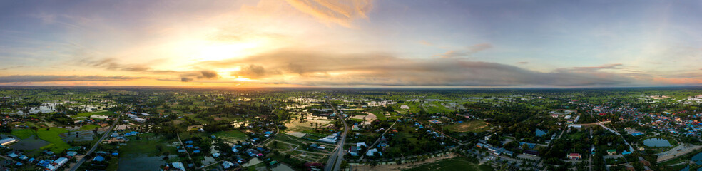Fototapeta na wymiar Panorama Top view Aerial photo from flying drone over village in Thailand.Top view beautiful Sunset.Sunrise with cloud over rice field.