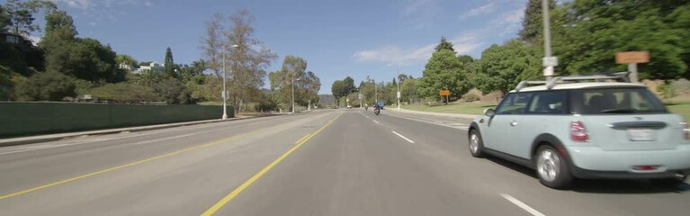 Front view of a Driving Plate: Car traveling on Temescal Canyon Road in Pacific Palisades, California, turns right onto Sunset Boulevard and continues to a stop light at the intersection of Via De La Paz.