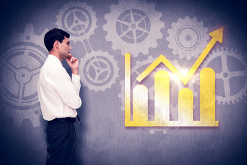 Thoughtful young businessman looking away against white and grey background