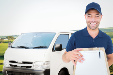 Happy delivery man with package and clipboard against scenic landscape