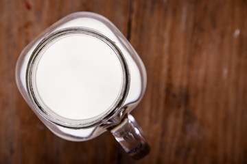 top view image milk in a jug and a glass  on wooden table.