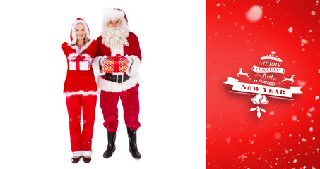 Santa and Mrs Claus smiling at camera offering gift against red vignette