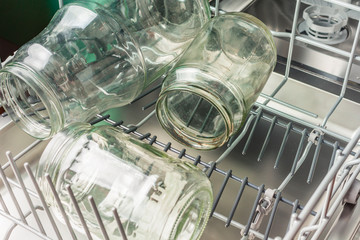 Glass jars are loaded in the lower compartment of the dishwasher