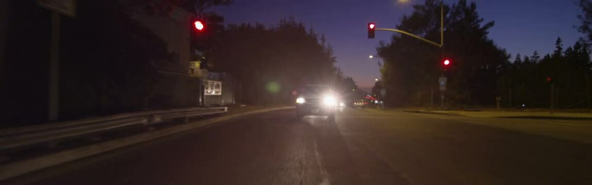 Rear view of a Driving Plate: Car travels eastbound on West Colorado Boulevard in Pasadena, California at dusk from San Rafael Avenue across bridge and continues to St John Avenue.