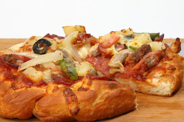 Pizza beef chicken peperoni cheese chilli capsicum onion olive on wooden board