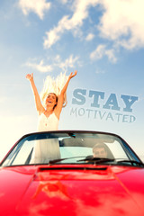 Happy woman standing in cabriolet while her boyfriend driving against stay motivated