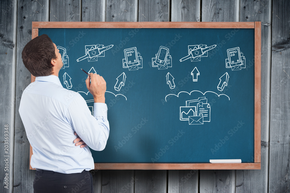 Canvas Prints Thinking businessman holding pen against blackboard with technology doodles