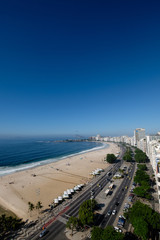 view of Copacabana beach right side during early morning, taken from the rooftop of a hotel, some slight fog can be seen on the blue sky. Rio de Janeiro, Brazil