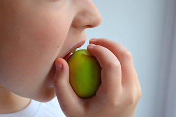 A child bites an Apple close-up.