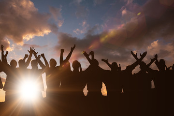 Fototapeta premium Silhouetters celebrating against clouds
