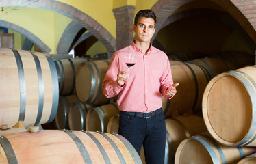 Male owner of winery standing with wine
