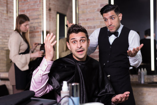 Unpleasantly surprised man and hairdresser regretting in salon
