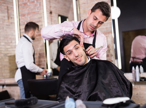 Barber shaving client with straightl razor